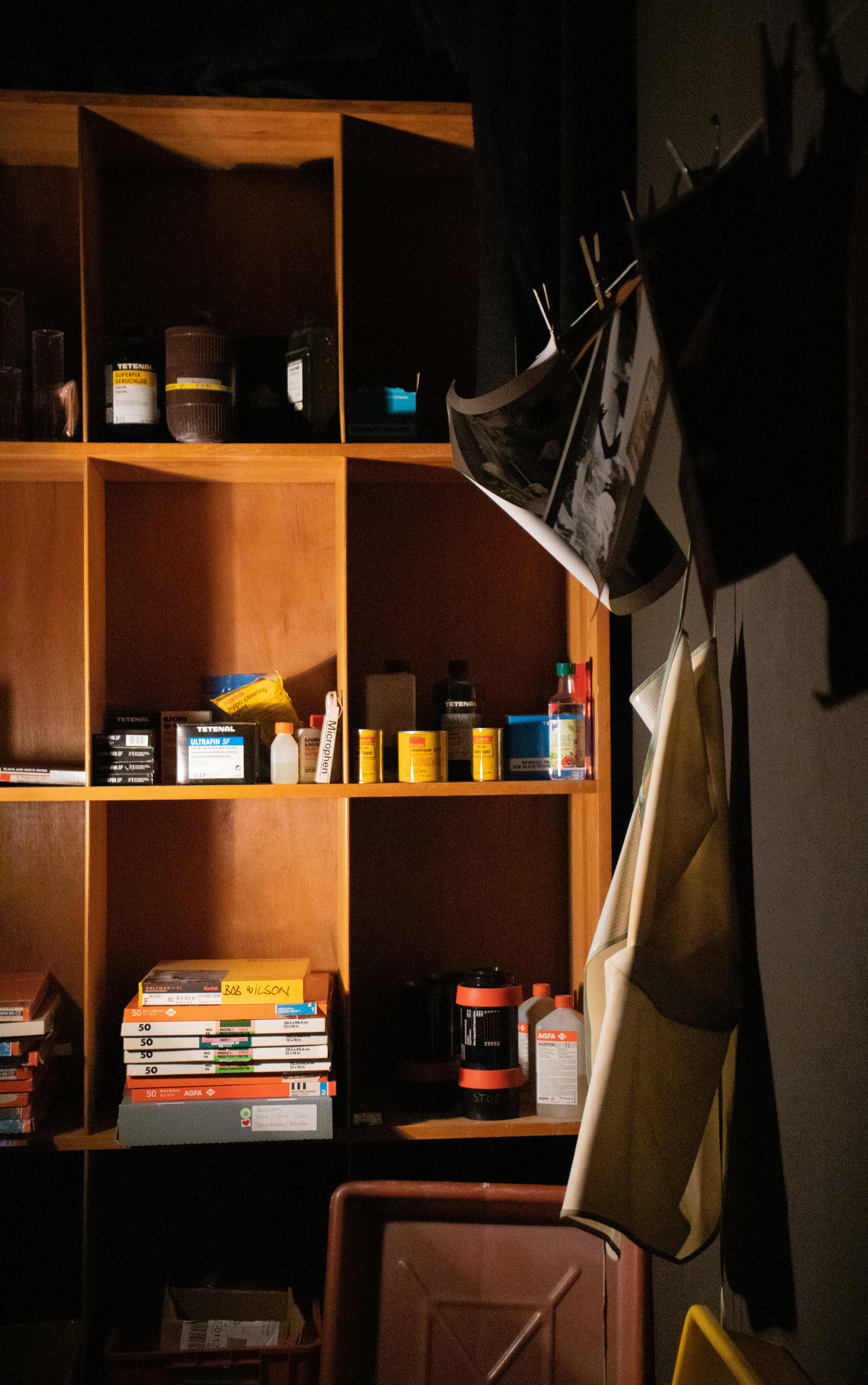 Wooden shelf of boxes, bottles and hanging prints