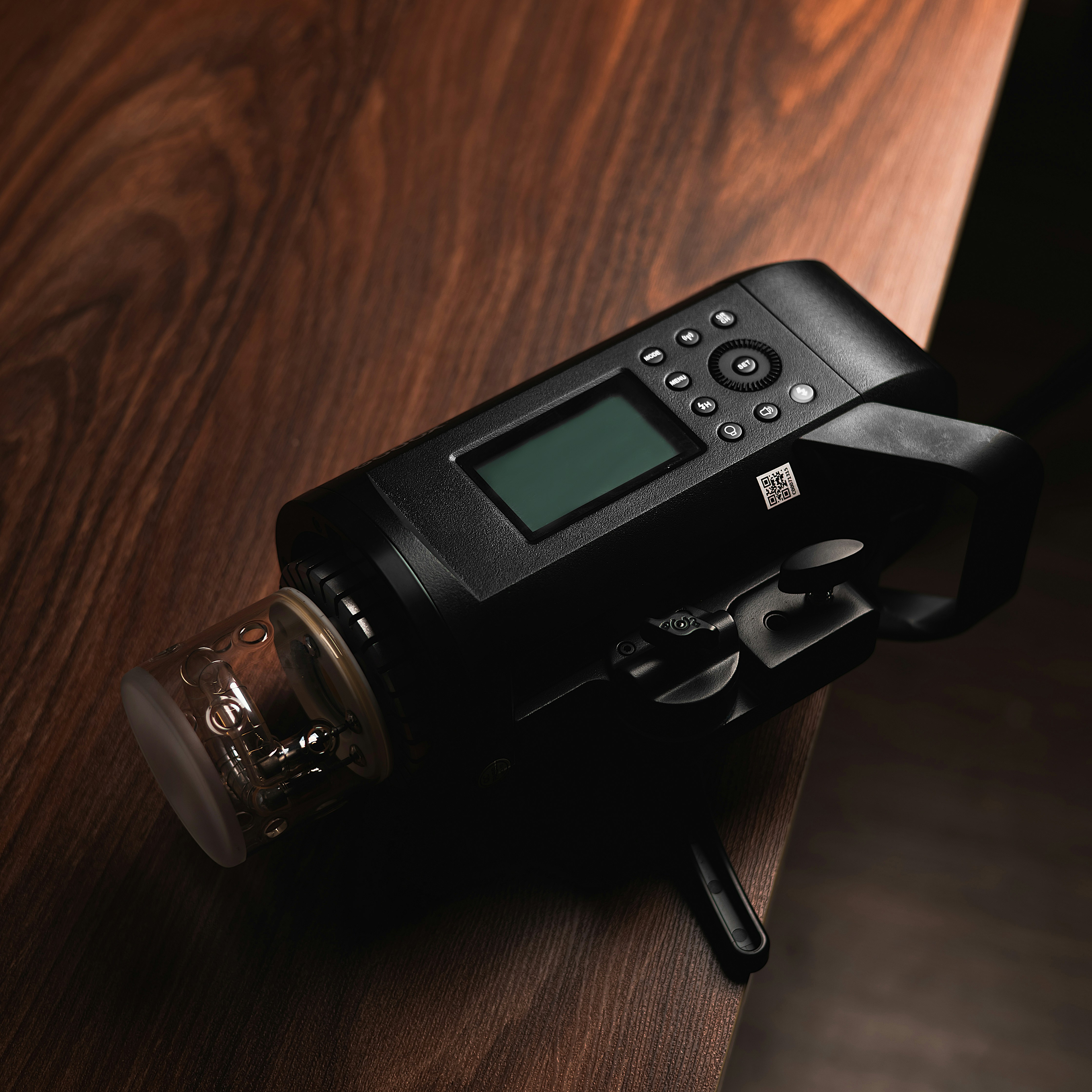 Studio flash lying on a dark wooden table