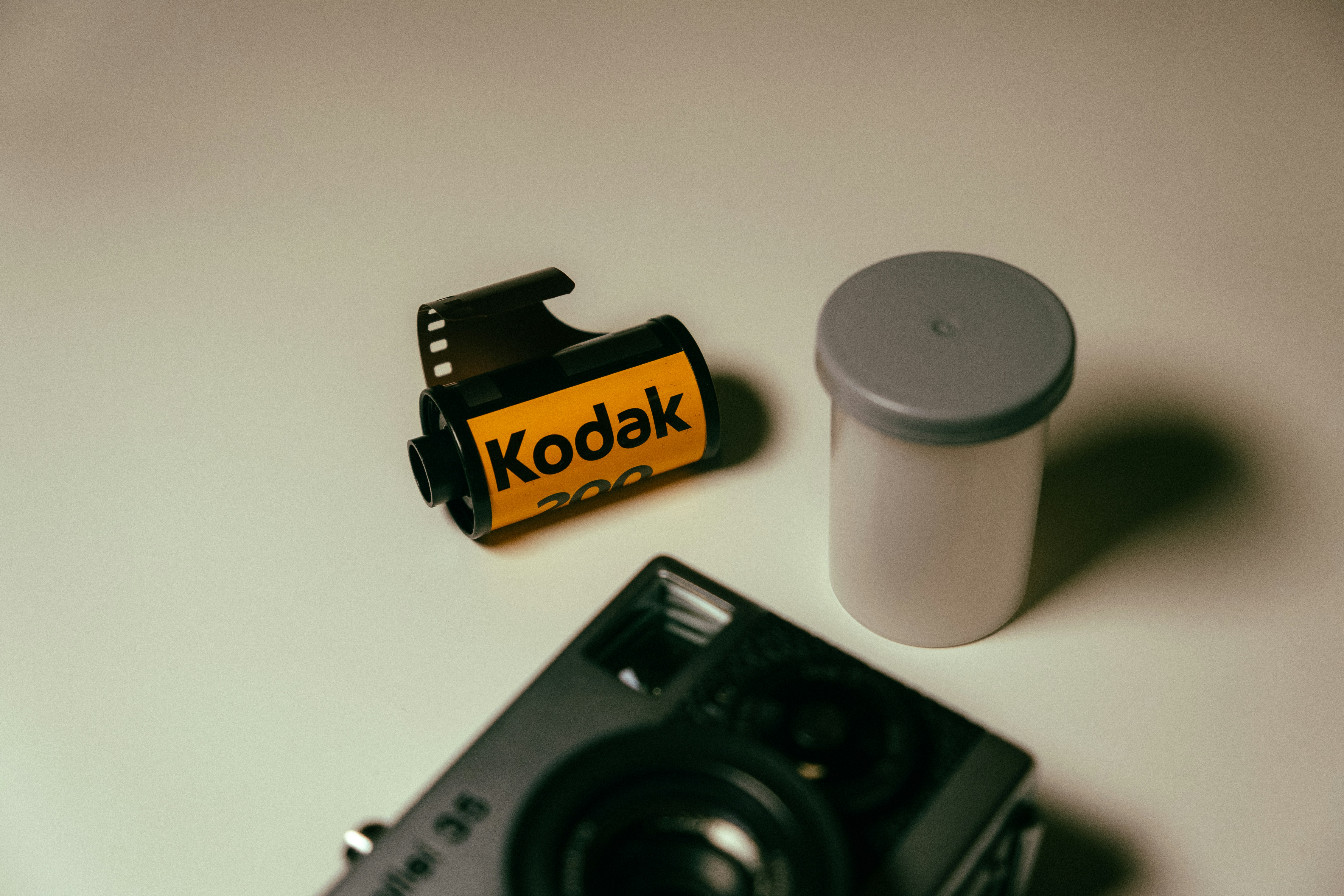 Still life of a film camera and a roll of film on white